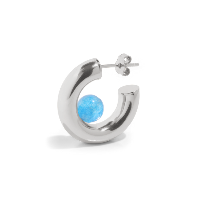 a silver hoop earring with a blue quartz gemstone positioned inside the open hoop