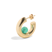 a gold hoop earring with a green quartz gemstone positioned inside the open hoop