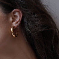 close up of woman's ear with a gold hoop 