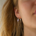 Sterling silver hoops with triangle twisted design on a woman with blonde hair