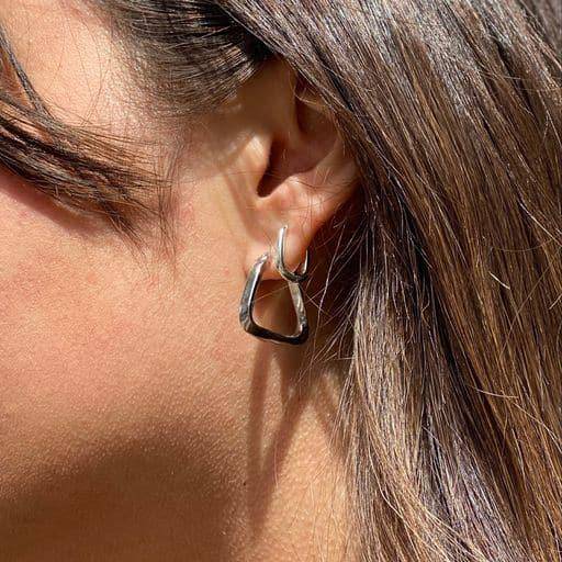 Sterling silver hoops with triangle twisted design on a woman with brown hair