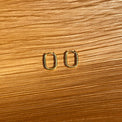 a pair of oval earrings sitting on top of a wooden table 