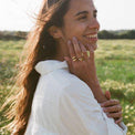 a woman in a white dress talking on a cell phone 