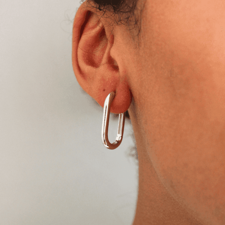 a man holding a pair of scissors to his ear 