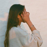 a woman in a white dress talking on a cell phone 